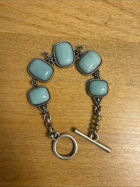Silver tone chain link toggle bracelet with light blue stone like accents